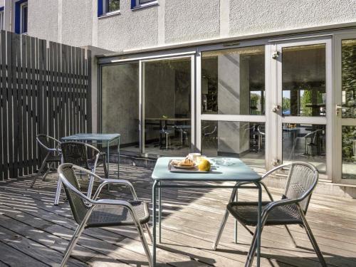a patio with chairs and a table with a plate of food on it at ibis budget Arles Sud Fourchon in Arles