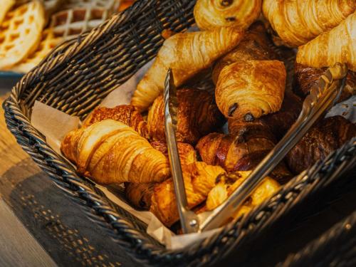 una cesta llena de varios tipos de croissants y pasteles en ibis budget Rennes Route de Saint Malo, en Montgermont