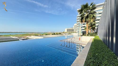 a swimming pool in front of a building at Maison 2BR Mayan within 10 Min to Grand Prix in Abu Dhabi