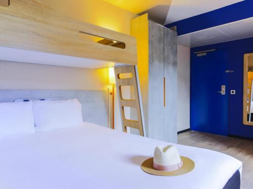 a hat is sitting on a bed in a room at Ibis Budget Albi Centre in Albi