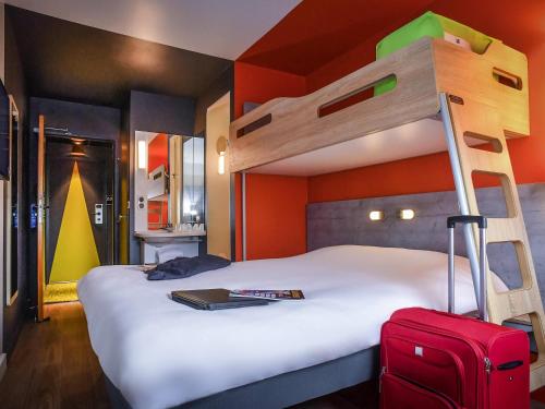 ein Schlafzimmer mit einem Etagenbett mit einem Koffer in der Unterkunft ibis budget Amboise in Amboise