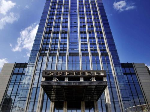 a tall building with a sign in front of it at Sofitel Kunming in Kunming