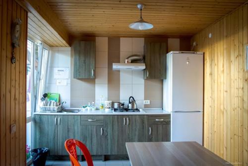 a kitchen with a table and a white refrigerator at Novyi Sezon in Olginka