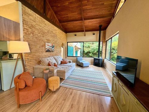 a living room with a couch and a tv at Casa com Jacuzzi e Área Gourmet em Mury in Muri