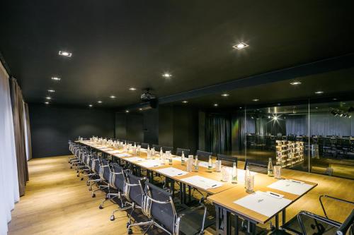 a long table with chairs in a large room with wine racks at Pytloun Grand Hotel Imperial in Liberec