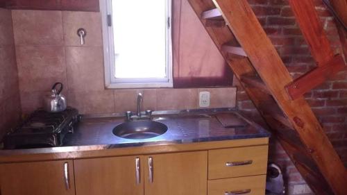 Una pequeña cocina con fregadero y ventana. en Paraje del Molino Casa Alpina, en San José