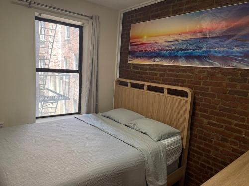 a bed in a room with a brick wall at Weehawken Apartment NYC Skyline in Weehawken