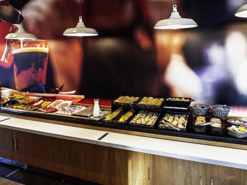 a buffet line with sushi and a drink at ibis Juiz de Fora in Juiz de Fora