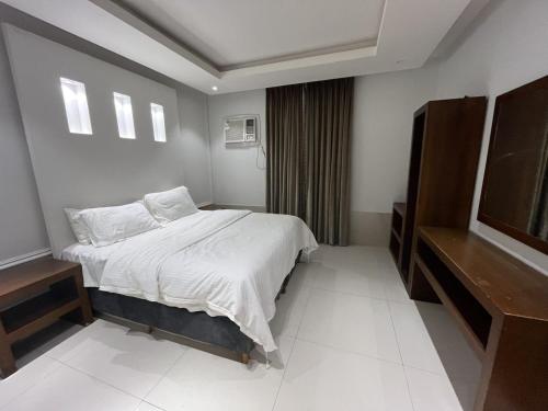 a bedroom with a bed with white sheets and pillows at شقق مفروشه رقميه في العزيزيه in Riyadh