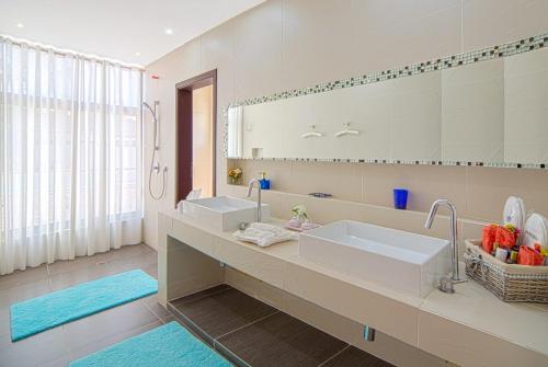 a bathroom with two sinks and a large mirror at Luxurious beachfront house Las Brisa in El Limón