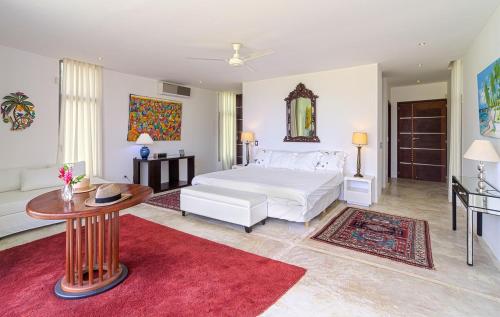a bedroom with a white bed and a table at Luxurious beachfront house Las Brisa in El Limón