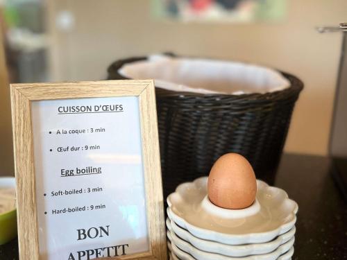 Un huevo en un bol junto a un cartel y una cesta. en Ibis Budget Saint-Martin-de-Crau Porte de Camargue, en Saint-Martin-de-Crau