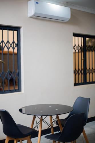 stół i krzesła w pokoju ze ścianą w obiekcie Palms & Pebbles Lodge w mieście Lilongwe