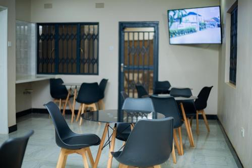 a meeting room with chairs and a table and a tv at Palms & Pebbles Lodge in Lilongwe