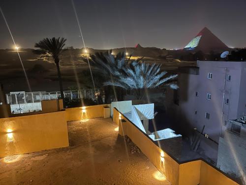 Una vista nocturna de una azotea con un edificio y palmeras. en ABAr, en Banī Ghālib