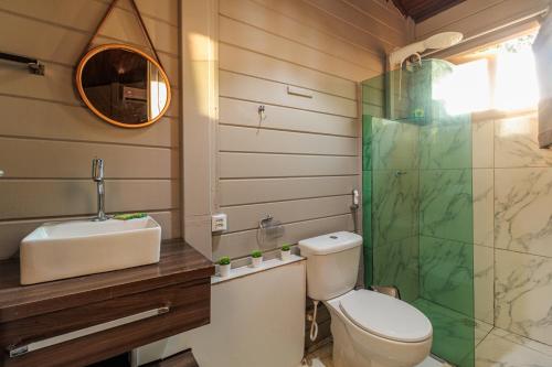 a bathroom with a toilet and a sink and a mirror at Pousada Piraúna in Fernando de Noronha