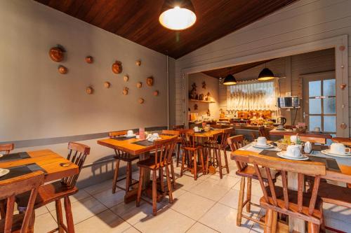 a dining room with wooden tables and chairs at Pousada Piraúna in Fernando de Noronha