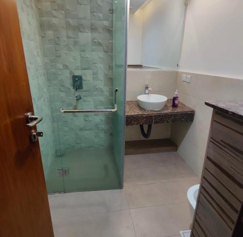 a bathroom with a glass shower with a sink at Gold Crest Apartments - 1 2 3 4 Bedroom By luxuryapartmentspk in Lahore