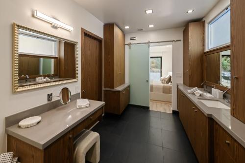 a bathroom with two sinks and a large mirror at Valea Estate in Beverly Glen