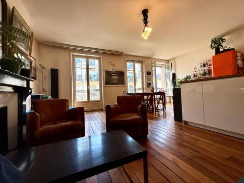 una sala de estar con sillas y una mesa en Bel appartement à Paris, en París
