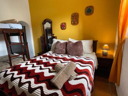 une chambre avec un lit avec une couverture rayée dans l'établissement Casa Loma, à Zapatoca