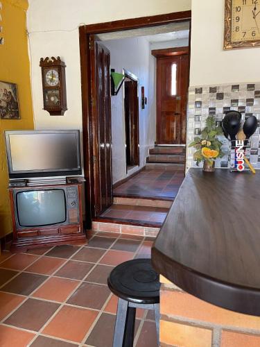 - un salon avec une télévision et un miroir dans l'établissement Casa Loma, à Zapatoca