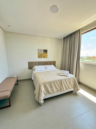 a bedroom with a large bed and a large window at Costa do Sauípe 5 suítes, piscina, hidromassagem e área de lazer completa in Mata de Sao Joao