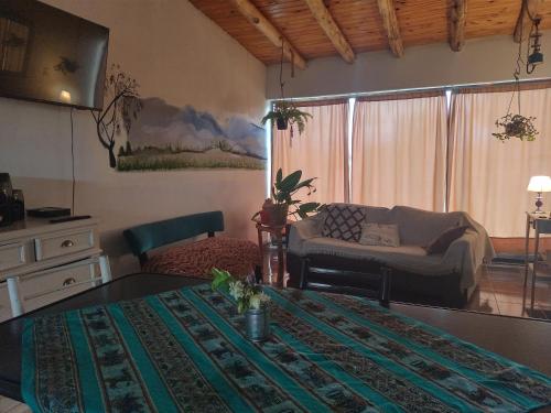 a living room with a couch and a table at Cabaña Hurú Zaha in La Consulta