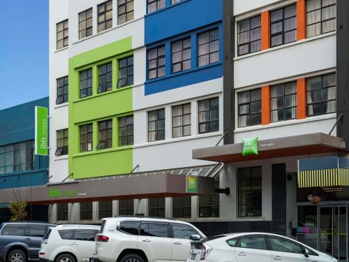 a building with cars parked in front of it at Ibis Styles Invercargill in Invercargill