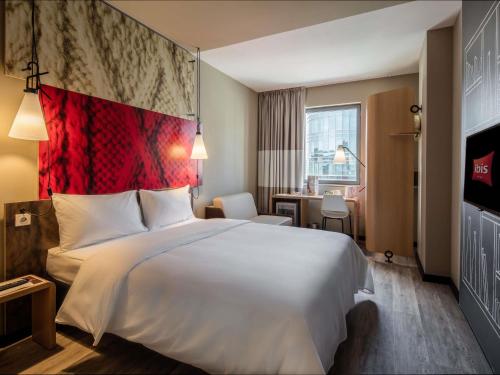 a hotel room with a large bed and a desk at Ibis Istanbul West in Istanbul