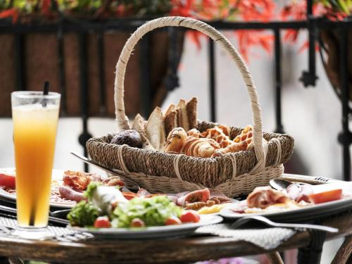 a table with a basket of bread and plates of food at Mercure Danang French Village Bana Hills in Da Nang