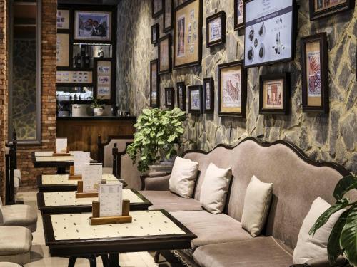 a restaurant with couches and tables in a room at Mercure Danang French Village Bana Hills in Da Nang
