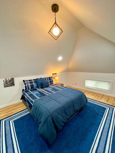 Un dormitorio con una cama grande con un edredón azul. en NYC-Style Loft with Secret Entrance - Just 6 Miles from Times Square, en North Bergen