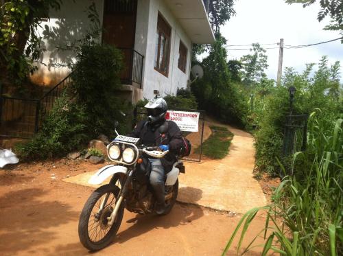 a man riding a motorcycle down a dirt road at Witherspoon Lodge in Kandy