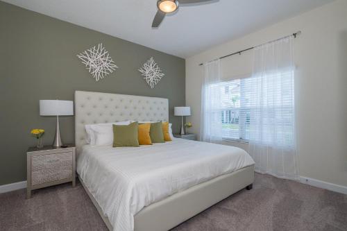 a bedroom with a white bed and a window at 4964RS TOWNHOUSE 4 BEDROOMS & 3 BATHROOMS + POOL in Kissimmee