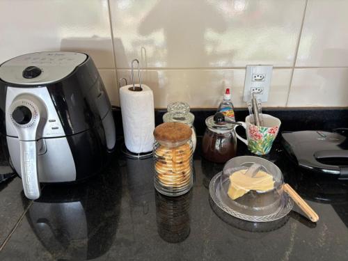 a counter top with a coffee maker and some food at Tríade Chalé da Canastra 2 in São Roque de Minas