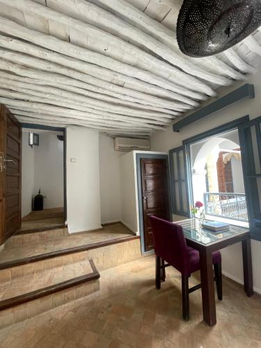a dining room with a table and a window at Riad Narjiss in Rabat