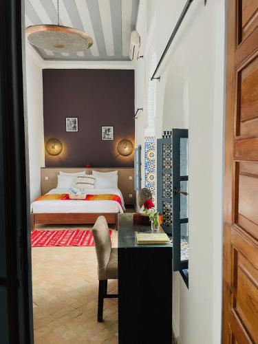 a bedroom with a bed and a desk and a table at Riad Narjiss in Rabat