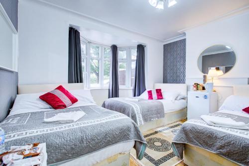 a bedroom with two beds and a mirror at Twin Towers Hotel in London