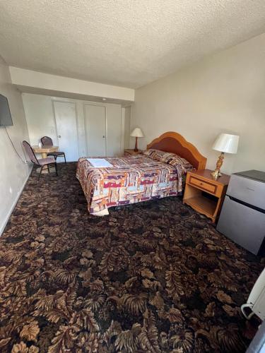 a hotel room with a bed and a table with a lamp at York Motel in Los Angeles