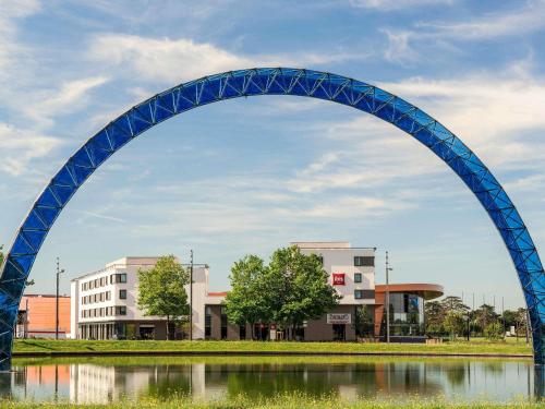 a blue arch over a body of water at ibis Saint Quentin en Yvelines - Vélodrome in Montigny-le-Bretonneux