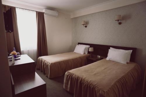 a hotel room with two beds and a window at C&C Residence Hotel in Bacău