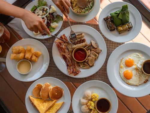 a table full of plates of breakfast food at Pullman Phuket Panwa Beach Resort in Panwa Beach