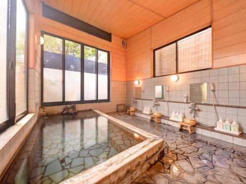 a bathroom with a large pool of water in a tub at Yufuin Yamaboushi in Yufu