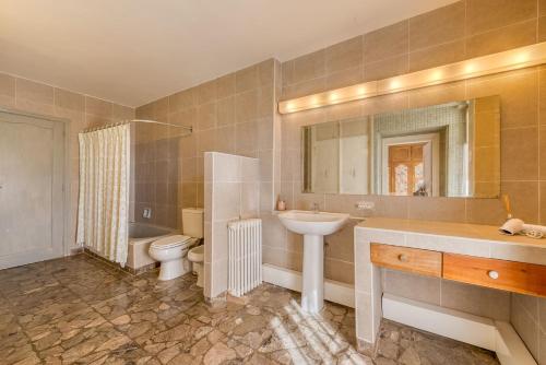 Un baño con lavabo, inodoro y espejo. en TEROTERO Lake Hostel - Habitación Nahuel 2, en San Carlos de Bariloche