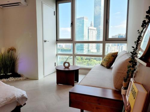 a living room with a couch and a large window at 슈기스테이 in Seoul