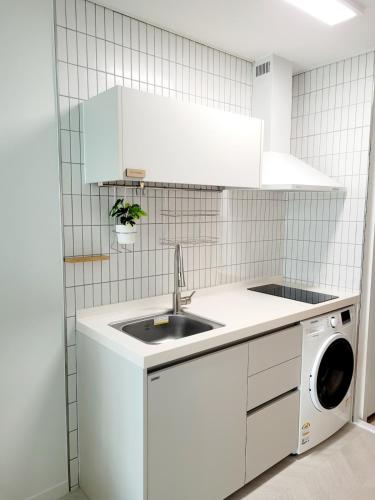 a white kitchen with a sink and a dishwasher at 슈기스테이 in Seoul