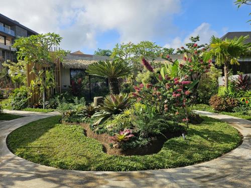a garden with flowers and plants in front of a building at Widji Garden Villa in Uluwatu