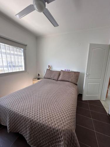 a bedroom with a bed with a ceiling fan at Serena in Concepción del Uruguay