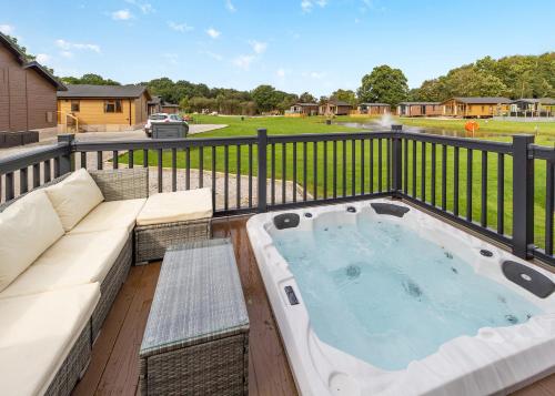 un jacuzzi sur un balcon avec un canapé dans l'établissement Ladera Retreat Lodges, à Eaton